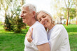 © Богдан Маліцький - elderly couple of seniors man and woman hugging and smiling in the park outdoors, gray-haired grandparents in white T-shirts in nature