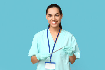 Canvas Print - Portrait of female doctor with tongue depressor on blue background