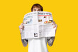 © Pixel-Shot - Handsome young man with newspaper on yellow background