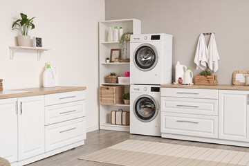 Poster - Interior of modern laundry room with washing machines and cleaning supplies