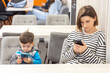 © Alexandra - mother and son,woman and baby boy,kid,are using smartphone sitting in cafe.focused mom and child, gadget addiction problem, mobile phone in hands.female ignoring toddler.