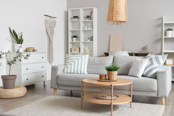 Poster - Interior of light living room with grey sofa, coffee table and plants