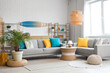 © Pixel-Shot - Light interior of living room with cozy sofa, coffee table, lamp and surfboard