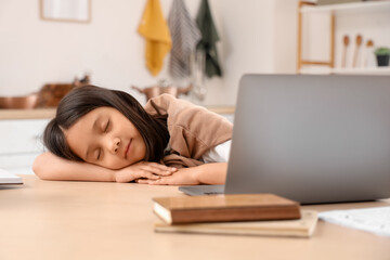 Wall Mural - Tired little Asian girl with laptop sleeping at home