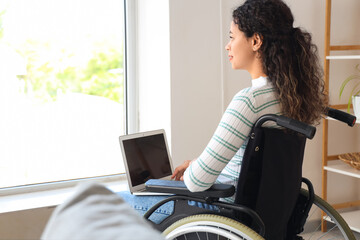 Sticker - Young African-American woman in wheelchair with laptop at home