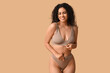 © Pixel-Shot - Beautiful young happy African-American woman in underwear on beige background