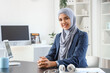 © Pixel-Shot - Beautiful Muslim businesswoman sitting at desk in office