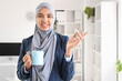 © Pixel-Shot - Beautiful Muslim businesswoman with coffee cup in office