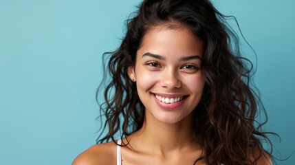 Wall Mural - portrait of smiling happy young hispanic woman against plain studio background lifestyle photography