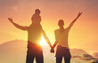 © kieferpix - Happy family together with arms up to the beautiful sunset sky