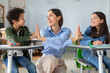 © Home-stock - Happy European female teacher, schoolgirl and schoolboy cheering, giving high five to each other and smiling, satisfying of tests result