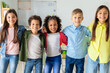 © Home-stock - Group portrait of happy diverse school friends. embracing and posing in classroom, looking at the camera and smiling