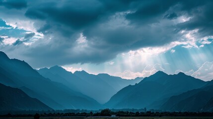 Wall Mural - A striking contrast of immense dark mountains set against the delicate glowing clouds above.