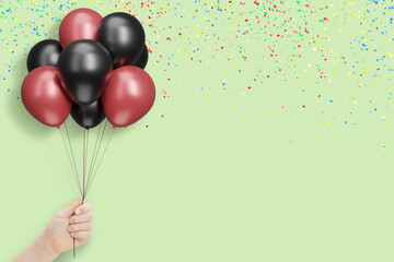 Aufkleber - Female hand holds bunch of red and black balloons on mint background with confetti. Empty space for text