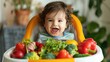 © Vladyslav  Andrukhiv - Toddler in a baby's chair with a giant bowl of vegetables - happy child with colorful vegetables