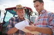 © tunedin - Two farmers discussing data from clipboard on the farm
