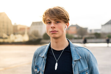 Wall Mural - Denmark, Copenhagen, portrait of young man with earbuds in the city