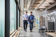 © tunedin - Two men walking in factory shop floor talking about product