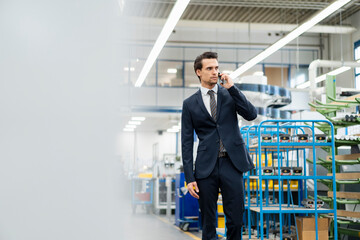 Canvas Print - Businessman on cell phone in a factory