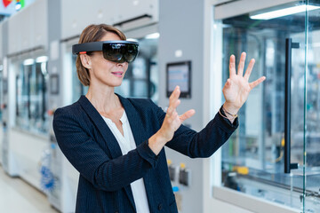 Canvas Print - Businesswoman wearing AR glasses in a modern factory