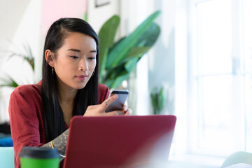 Sticker - Woman using cell phone and laptop in office