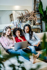 Poster - Three happy women with laptop sitting on couch