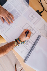 Close-up of architect working at home on floor plan