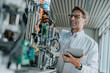 © tunedin - Smiling male scientist holding digital tablet examining machinery in laboratory