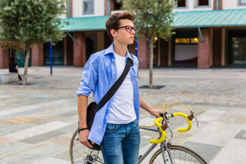 Canvas Print - Young man pushing his bike