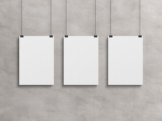 Wall Mural - Three Blank vertical poster hanging with clips on a wall Mockup. 3D rendrering