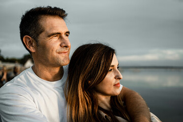 Wall Mural - Smiling man looking away while embracing woman