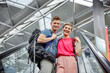 © tunedin - Happy couple on escalator at the airport