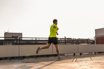 Wall Mural - Young man running on parking level