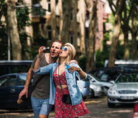 Poster - Couple blowing soap bubbles in the city together