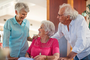 Wall Mural - Senior woman signing a contract, friends reassuring her