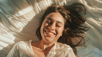 Sticker - Sun-kissed woman beaming with joy on a cozy bed.