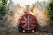 © dusanpetkovic1 - Rear view of agricultural vehicle with sprayer machine spraying hazel trees at countryside.