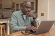 © ReeldealHD images - Senior man at home in his kitchen using a laptop for personal finances