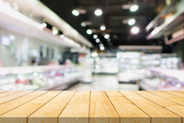Wall Mural - Empty wood table top with supermarket blurred background for product display