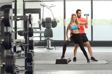 Canvas Print - Male trainer exercising with a young woman