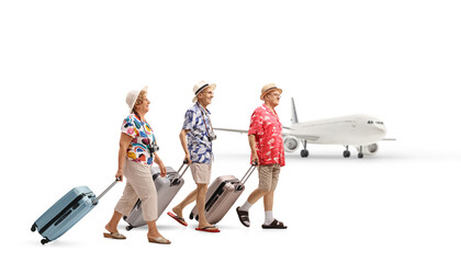 Sticker - Full length profile shot of senior tourists with suitcases at an airport