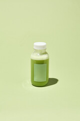 Leinwandbilder - Minimalist Green Smoothie Bottle on Pastel Background - Creative Conceptual Pattern with Colorful Shadows