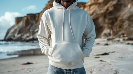 Wall Mural - Cropped image of man in white hoodie standing on the beach
