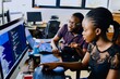 © MD Media - A woman is pointing at the computer screen in front of her, and she has an african american man sitting next to him with his hands on top of each other.
