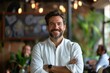 © Sandu - Man smiling standing white shirt arms crossed restaurant