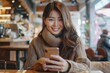 © Sandu - Woman using smartphone at table