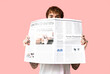 © Pixel-Shot - Handsome young man with newspaper on pink background