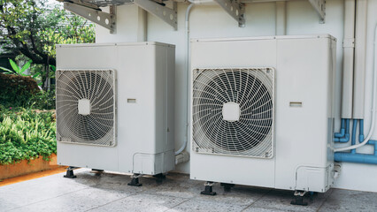 Two air conditioners are on the side of a building