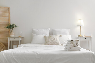 Wall Mural - Stack of white clean soft towels on big comfortable bed in bedroom