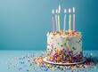 © Adila - A birthday cake with colorful sprinkles and candles on a blue background, copy space for text stock photo contest winner, in the style of stockphoto